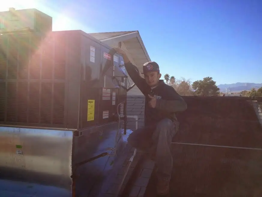 HVAC technician performing AC Tune-Up on a rooftop unit in Du Quoin